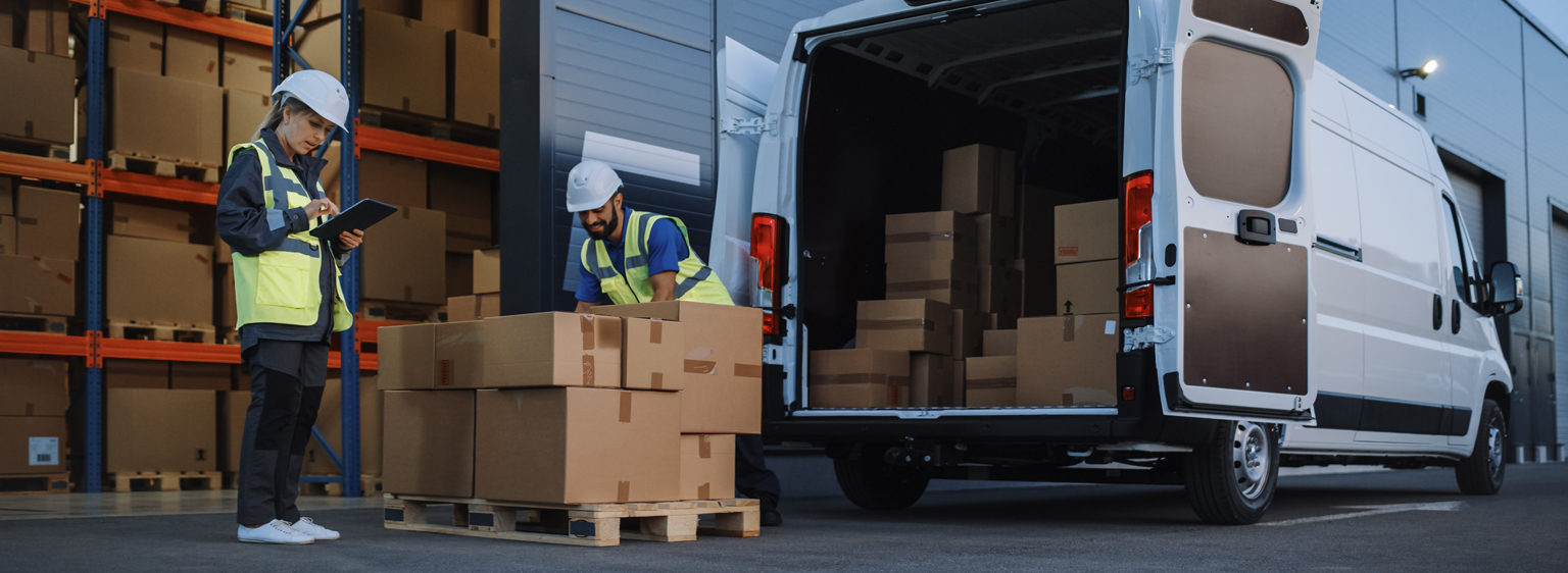 outside warehouse with boxes and a van