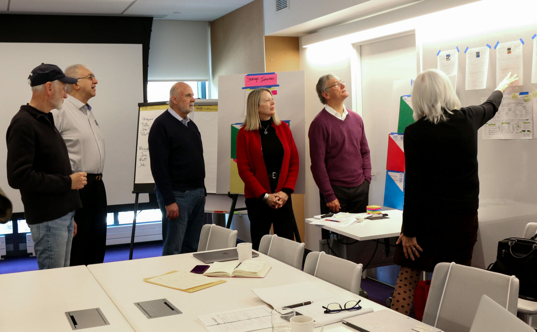 Jean talking to board of directors at a visual wall