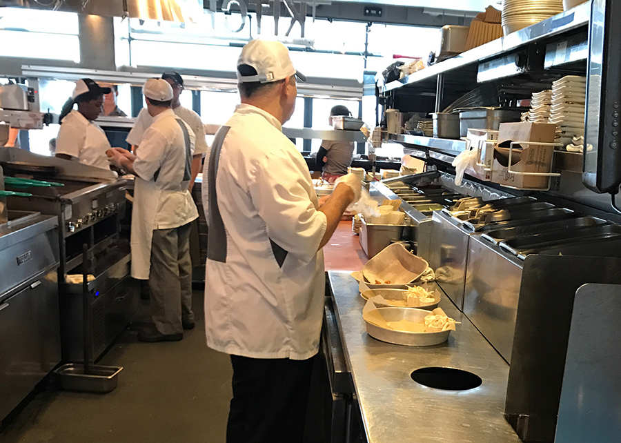 typical restaurant kitchen interior with cooks prepping food