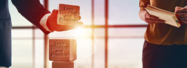 two businessman stacking blocks